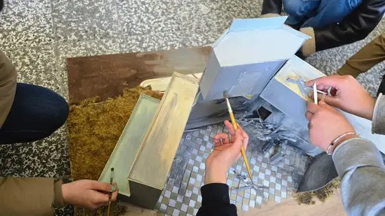 Nxënës duke punuar mbi një maket arkitektonik në edukimin shkencor