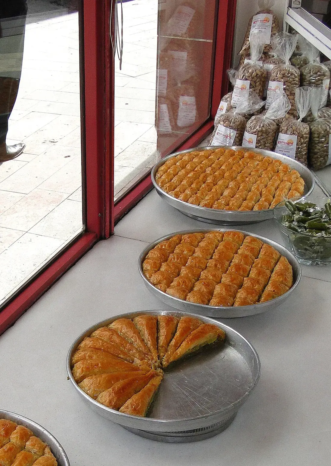 Gaziantep’te bir dükkânda sergilenen baklava tepsileri ve fıstık ürünleri